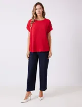 Blusa de crepe color blanco, con cuello redondo a la base y mangas cortas con detalle de presilla y botón en el borde.