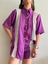 Camisa lila con paneles de red blanca en los laterales.