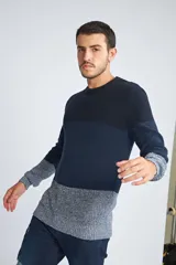 Sweater de punto con diseño color block en tonos azul marino y gris jaspeado. Presenta cuello redondo, mangas largas y un ajuste regular.