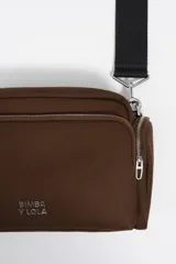 Bolso bandolera de tamaño mediano confeccionado en gabardina de algodón, con diseño funcional, cierre de cremallera y correa ajustable de tejido. Presenta el logo de la marca aplicado en el frente.