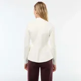 Sweater de tejido de punto color blanco, con cuello simulado (mock neck) y manga larga. Presenta un corte ajustado en el torso que se ensancha en un ruedo tipo peplum o volante a la altura de la cadera.