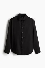 Camisa de manga larga en mezcla de lino y algodón color negro, con cuello inglés, bolsillo en el pecho y cierre frontal de botones.
