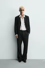 Pantalón de traje con corte relaxed fit, confeccionado en una mezcla de viscosa y lino. Presenta bolsillos laterales delanteros, bolsillos traseros de vivo y cierre frontal con cremallera y gancho oculto.