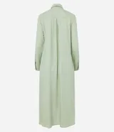 Vestido chemise largo color naranja, confeccionado en viscolino. Tiene cuello solapa, cierre con botones, manga larga con martingale, aberturas laterales y no tiene estampado.