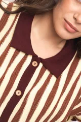 Vestido camisola de tejido de punto fresco, con rayas verticales en tonos marrones y beige, cuello polo marrón, mangas cortas y cierre frontal con botones de madera.