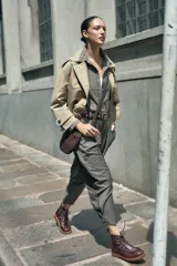 Bota de cuero vacuno color bordó con acabado charol, diseño de caña media con cordones y ganchos metálicos. Presenta costuras visibles en la puntera y suela de goma tipo crepe.