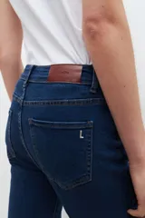 Jean slim azul oscuro, tiro medio, cinco bolsillos y corte ajustado.