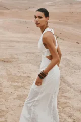 Vestido midi blanco con bordados florales perforados, escote en V, sin mangas y tirantes cruzados en la espalda.