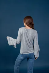 Blusa gris melange de punto tejido fino, con escote en V y mangas largas anchas terminadas en volados.