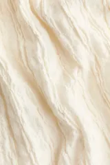 Vestido midi de color blanco con textura arrugada, escote en V, breteles finos y detalle drapeado en el busto.