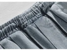 Pantalón de jean azul claro lavado, estilo cargo y corte ancho (baggy), con cintura elástica ajustable y bolsillos cargo laterales.