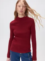 Remera de cuello alto tipo polera, confeccionada en tela rib con textura acanalada y ajuste al cuerpo. Presenta mangas largas y un pequeño bordado distintivo en la parte inferior.