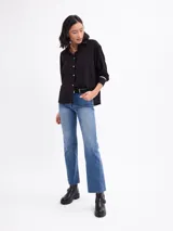 Camisa de manga larga color malva, con cuello clásico, cierre frontal con botones y detalles de vivos negros en los puños.