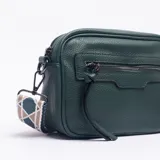 Bandolera de cuero sintético texturizado en color verde petróleo, con cierre frontal y correa ajustable de tela estampada con diseño geométrico.