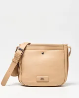 Bandolera beige de símil cuero con correa regulable y bolsillo frontal con broche a presión. Cuenta con aplique metálico con el logo de la marca en la parte inferior.