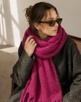 Bufanda amplia y abrigada de textura suave y acabado afelpado, color fucsia, con flecos en los extremos.
