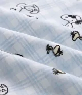 Pijama largo para hombre confeccionado en algodón, compuesto por una remera de manga corta blanca con cuello redondo celeste y estampa frontal de Snoopy, y un pantalón largo celeste con estampado general de Snoopy y cintura elástica.