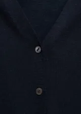 Cardigan de punto fino con cuello en pico y cierre frontal con botones. Presenta un diseño recto y mangas largas.