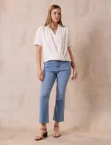 Blusa color blanco de lino, con cuello con solapa y escote en V. Delantera cruzada y mangas cortas. Marca Cable & Gauge.