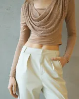 Top de manga larga color beige con escote drapeado y detalle de lentejuelas brillantes en la parte frontal.