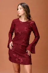 Falda corta de encaje color bordó con diseño floral en relieve, de corte recto y estilo femenino.