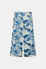 Pantalón de tiro medio con bolsillos laterales ocultos y pernera ancha, confeccionado con un vistoso estampado floral en tonos azules y blancos. Cuenta con cierre de cremallera lateral oculta en la costura.