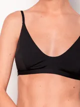 Top de bikini negro, de corte triangular con breteles finos fijos y ajuste trasero con broche.