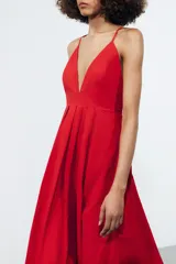 Vestido largo rojo de Zara Woman Collection confeccionado en hilatura con mezcla de algodón. Escote pico y tirantes finos cruzados en la espalda ajustable con lazadas. Tiene bolsillos laterales, detalle de pliegues en la cintura y cierre en la espalda con cremallera oculta en la costura.