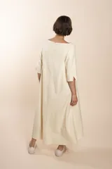 Vestido midi acampanado de lana fina sin teñir, con cuello bote, mangas tres cuartos con tajo y bolsillos laterales. Diseño forrado con vuelo y movimiento.