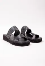 Sandalia con doble tira en el empeine, una de cuero color tostado y otra tejida en rafia. Plataforma de yute de 3.5 cm de alto.