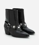 Bota corta de cuero sintético color negro, estilo western, con puntera fina, taco cuadrado y detalles de tachas plateadas.