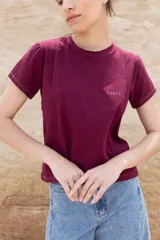 Remera color borgoña de algodón con cuello redondo y mangas cortas. Presenta costuras verticales en el frente y logo bordado en el pecho.