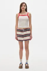 Musculosa blanca con cuello y sisas en rojo, con logo bordado en el pecho.