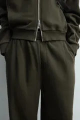 Pantalón jogger de algodón color verde oscuro, con efecto lavado, corte balloon fit y cintura elástica. Presenta bolsillos delanteros y bolsillos traseros de plastrón.