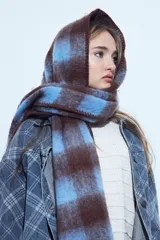 Bufanda oversized de textura suave con diseño a cuadros en tonos marrón y azul.