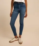 Pantalón de jean skinny azul con cintura alta y detalles de desgaste en los bolsillos.