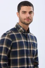 Camisa de viyela a cuadros en tonos marrón, azul marino y gris, con cuello clásico, cierre frontal con botones, mangas largas y un bolsillo en el pecho.