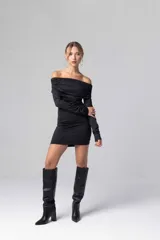 Vestido corto negro con escote bardot fruncido y mangas largas ajustadas.