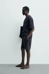 Bermuda estilo jogger de ajuste relajado, color negro, confeccionada en tejido interlock de algodón. Cuenta con cintura elástica ajustable mediante cordón, bolsillos delanteros tipo vivo y diseño liso.