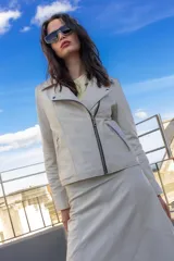 Chaqueta estilo motoquero confeccionada en cuero ovino color blanco. Presenta un diseño ajustado al cuerpo con cierre metálico cruzado, bolsillos laterales con cierres metálicos y solapas clásicas.