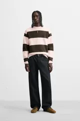 Jersey de punto de tacto suave con diseño de rayas horizontales anchas en color rosa claro y marrón oscuro. Presenta cuello redondo, manga larga y terminaciones en rib.