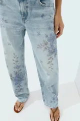 Jeans Z1975 de tiro medio y pernera recta con diseño de cinco bolsillos, cierre frontal con cremallera y botón, y delicado estampado floral en tonos azules.
