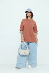 Remerón de manga corta color terracota con efecto gastado, silueta amplia y bolsillo aplicado con bordado de perro salchicha.