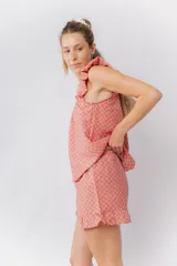 Pijama de algodón estampado, compuesto por una musculosa con escote recto fruncido y breteles con volados, y un short con cintura elástica y terminación con volado en el ruedo.