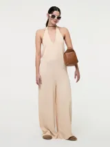 Mono largo color beige, con escote halter y espalda descubierta.