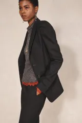 Blazer negro de corte recto de la colección Zara Studio, con solapas de muesca, cierre frontal de dos botones y bolsillos con solapa. Presenta mangas largas con pliegues estructurados en los hombros y forro interior a rayas a contraste.
