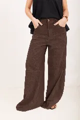 Pantalón de lino marrón, de tiro alto y corte wide leg, con bolsillos delanteros y cierre frontal de botón y cremallera.