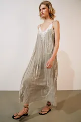 Vestido largo de viscosa color gris verdoso, con escote en pico, tirantes finos ajustables y detalles de bordados contrastantes en el cuerpo.