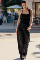Jeans de mezclilla en color negro con efecto lavado, de tiro alto y cinco bolsillos, con perneras extra anchas y cierre frontal con cremallera y botón metálico.