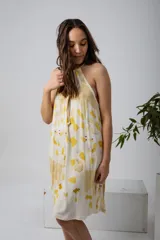 Vestido midi con estampado de hojas amarillas y marrones, corte suelto y cuello halter con lazo.